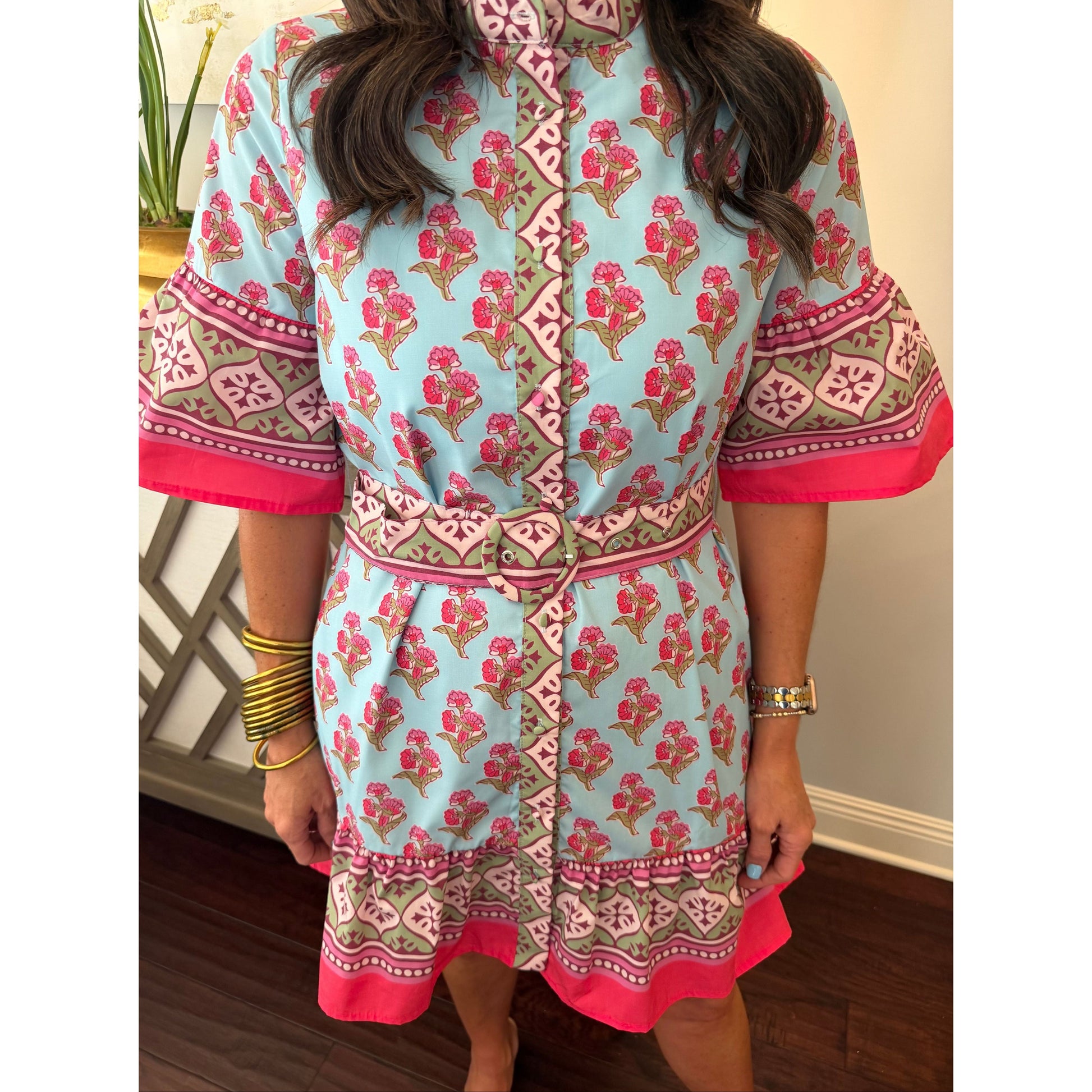 Person wearing a floral dress with pink and red patterns.