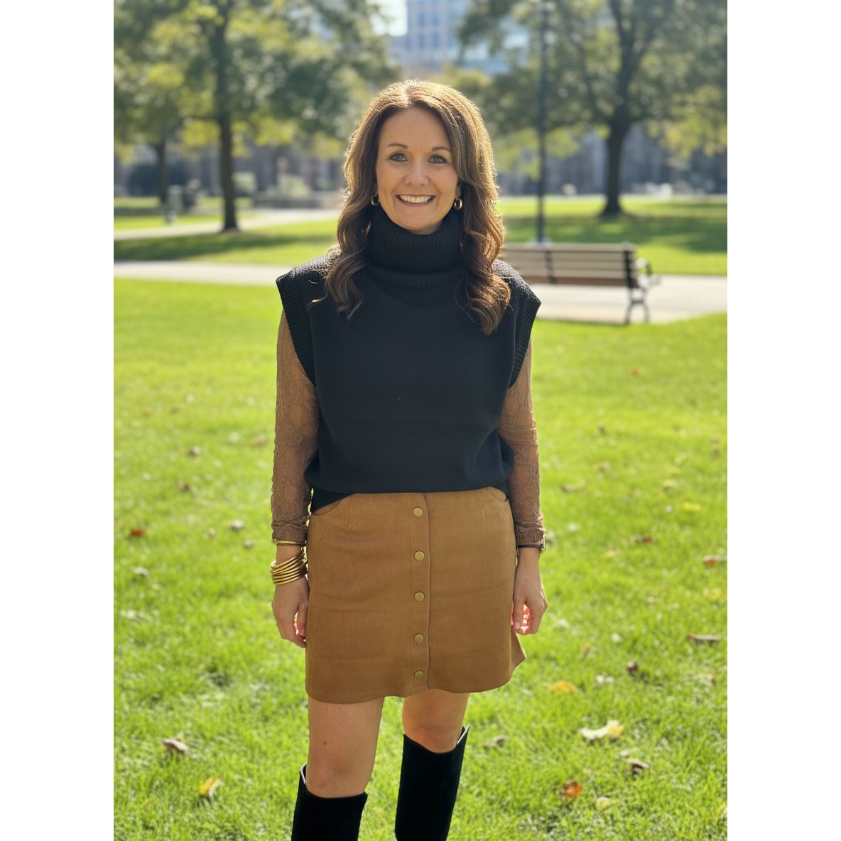 Person wearing a black hoodie and brown puffer vest.