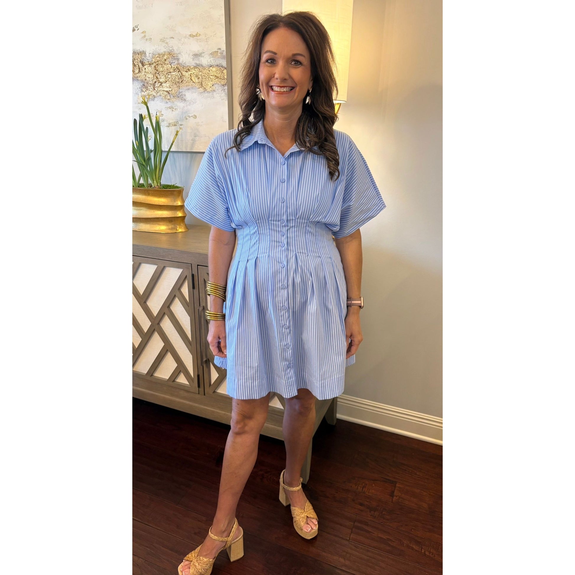 Woman wearing a blue and white striped dress indoors.