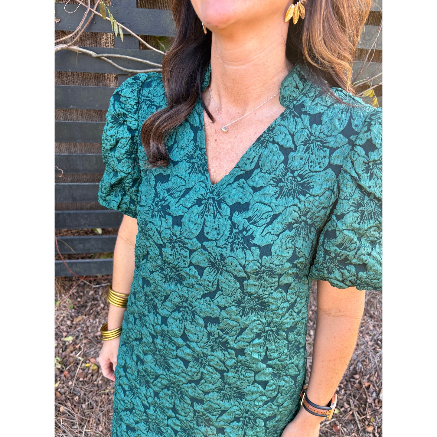 Woman wearing a green floral dress with a blurred background