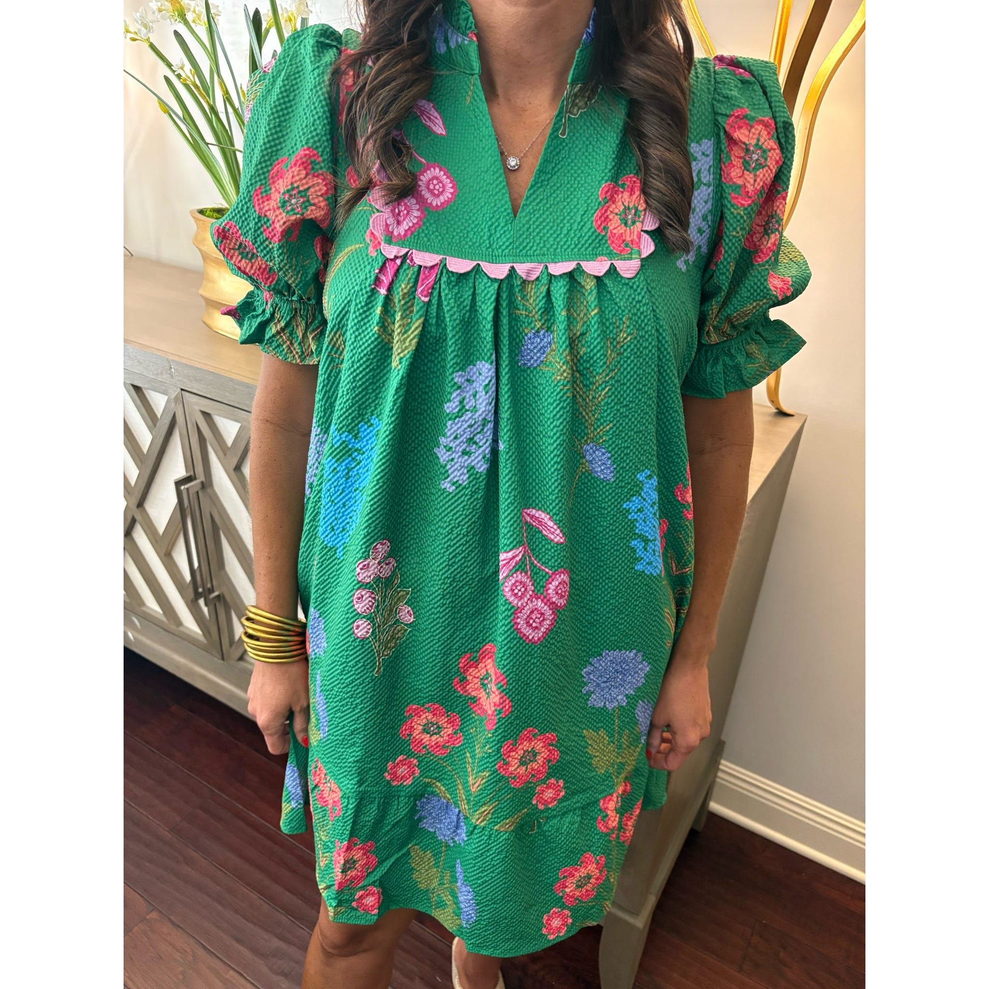 Woman wearing a green floral dress in an indoor setting