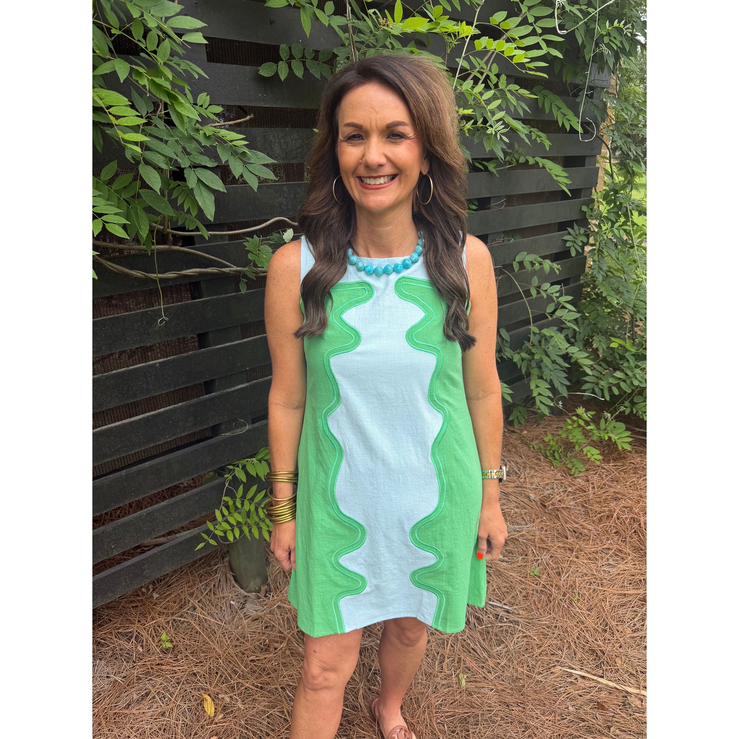 Woman holding a green and white towel outdoors