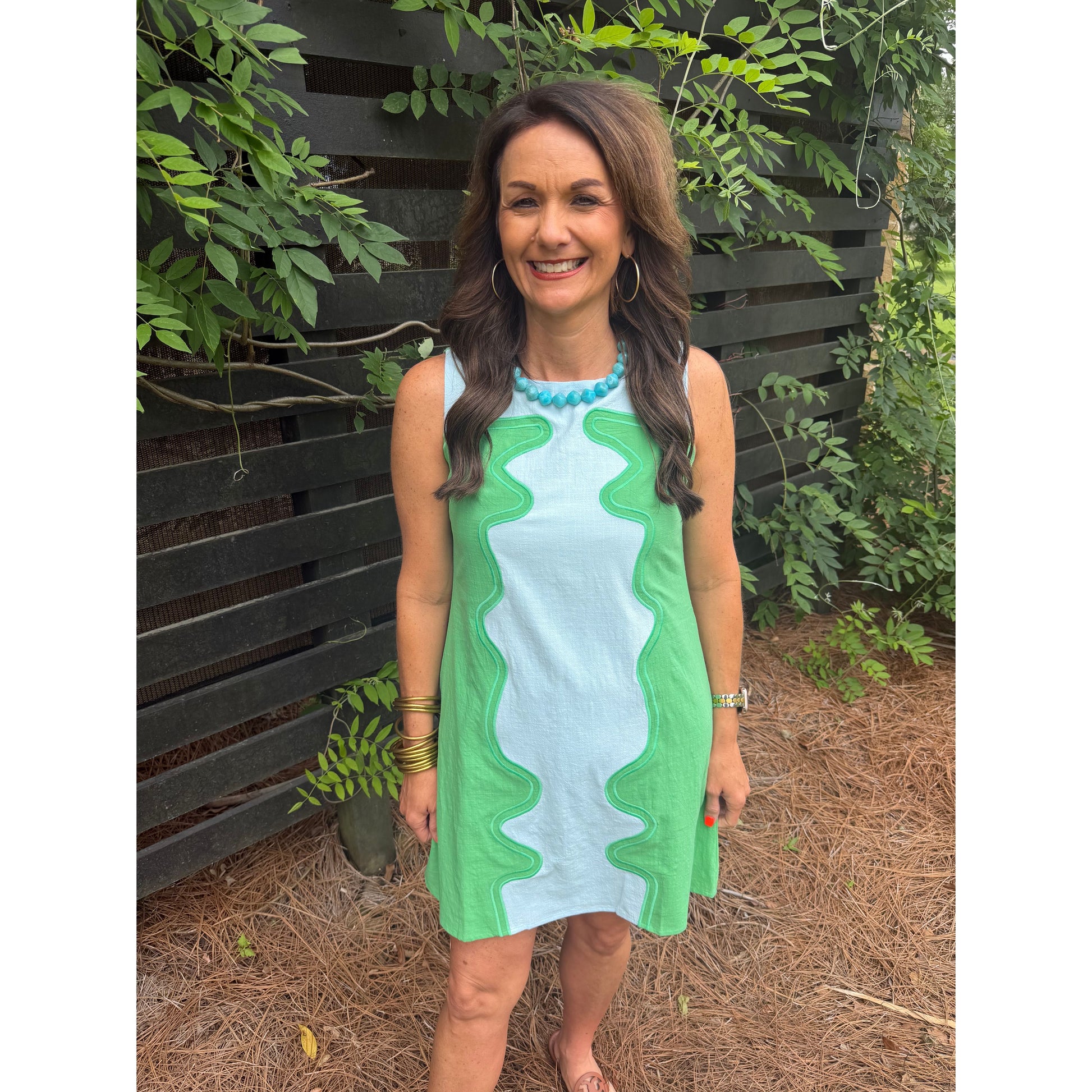 Woman holding a green and white towel outdoors