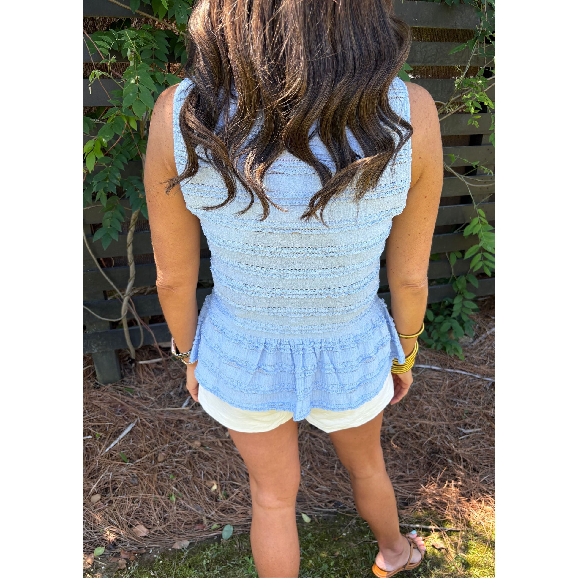 Person wearing a light blue dress with white trim in an outdoor setting