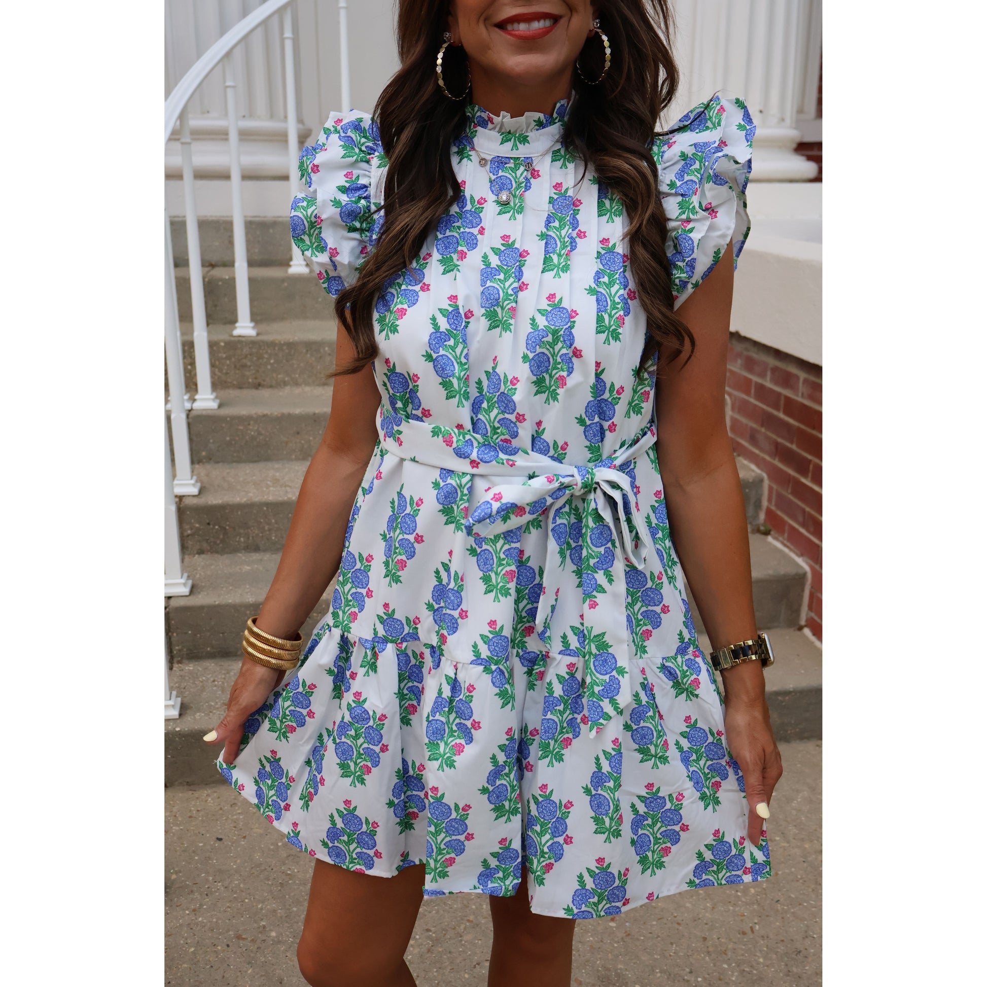 Woman wearing a floral dress with matching headscarf indoors.