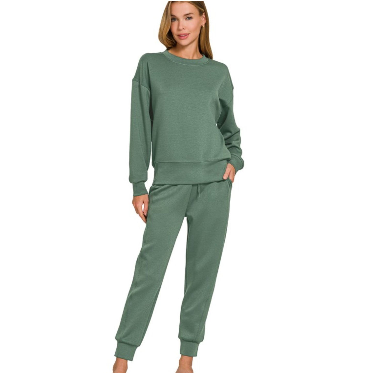 Woman wearing a green sweatshirt and pants set on a white background