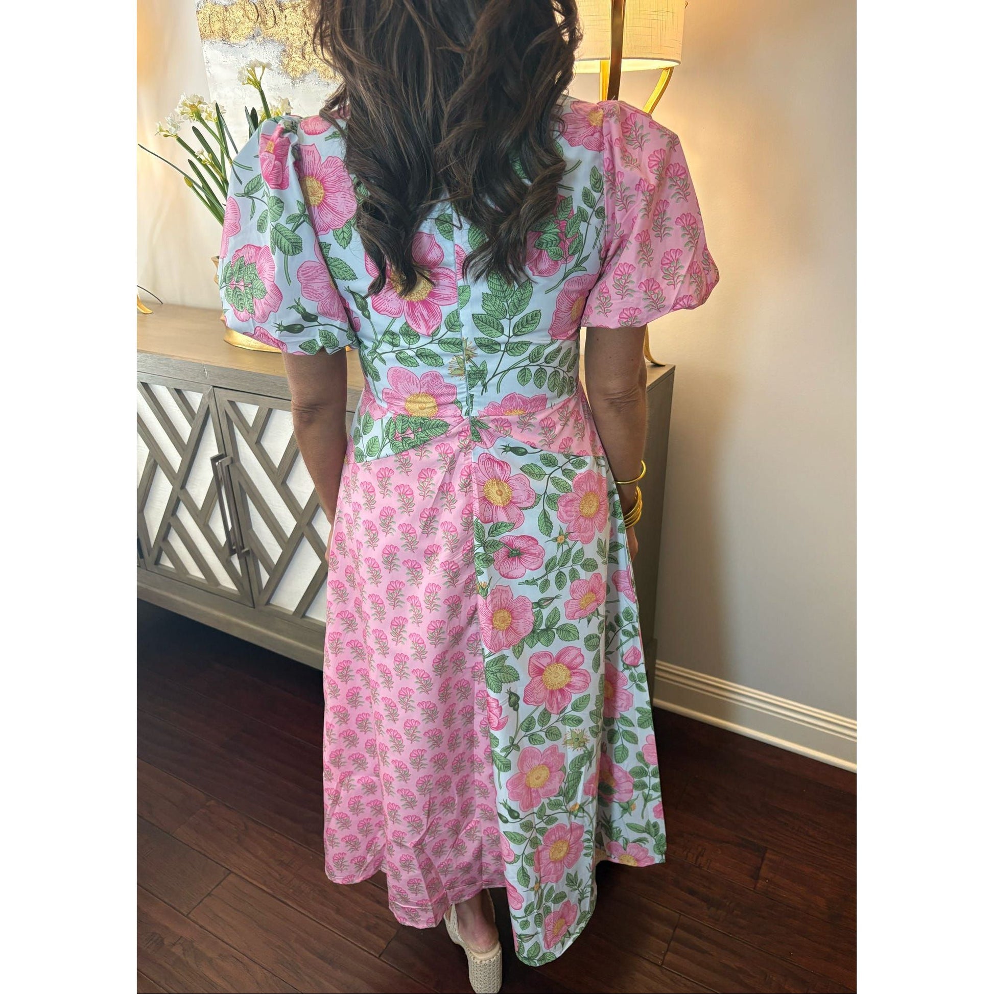 Person wearing a pink floral dress in an indoor setting