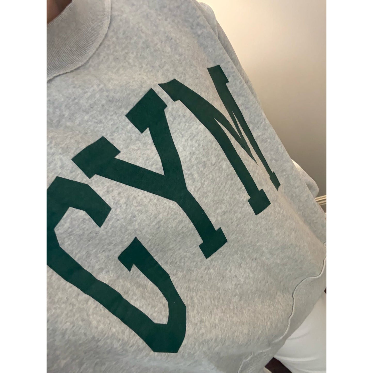 Gray sweatshirt with green 'Gym' text on a plain background
