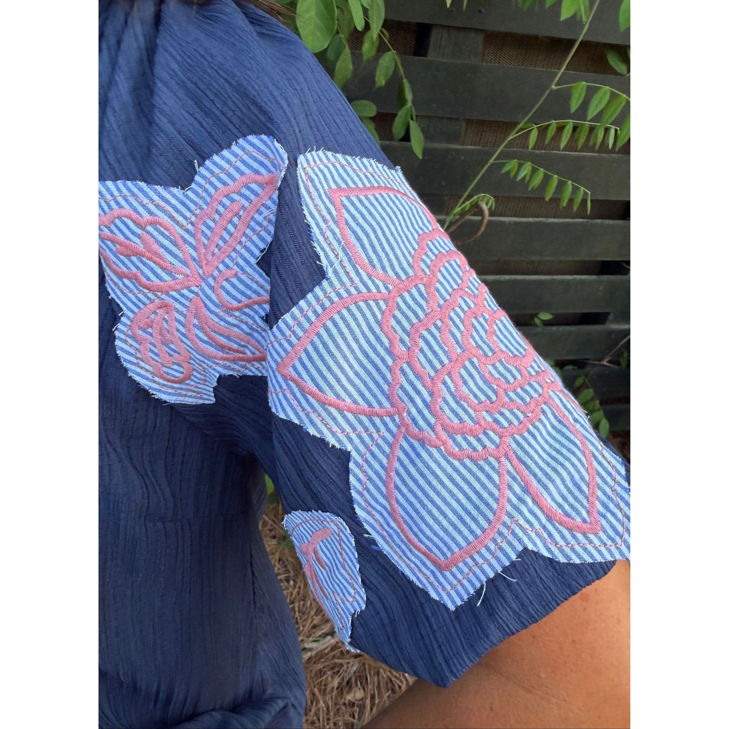 Blue and pink patterned glove held by a person with a blurred background