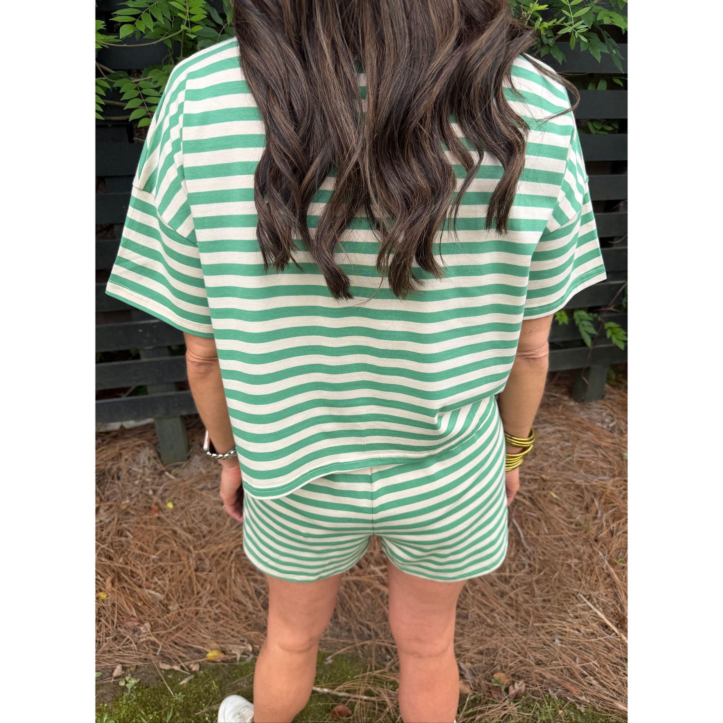 Green and white striped dress worn by a person, with a focus on the fabric pattern.