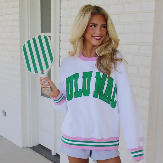 Woman wearing a white sweatshirt with green text, holding a green and white striped paddle.