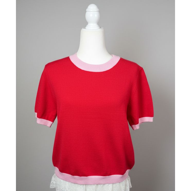 Red sweater with pink trim on a mannequin against a neutral background
