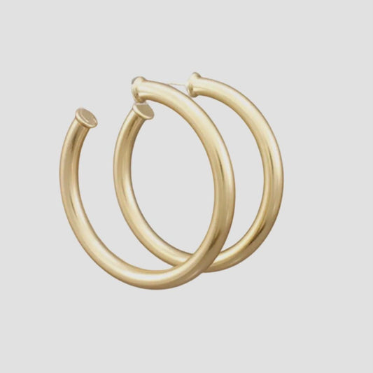 Gold hoop earrings on a light gray background