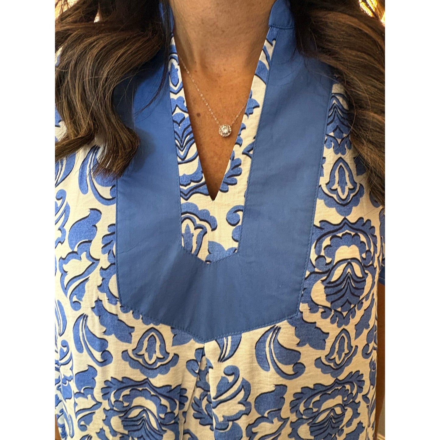 Close-up of a blue and beige patterned garment with a V-neckline.
