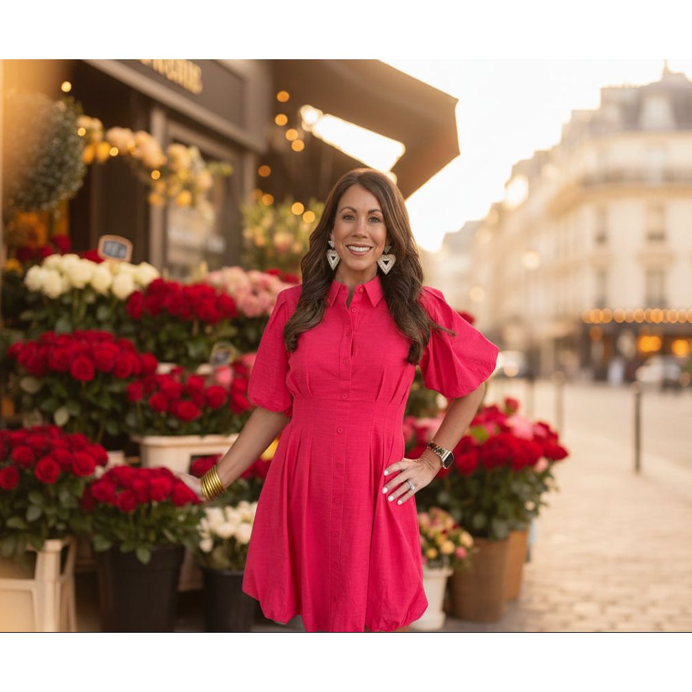 Woman in a red bubble dress standing at a flower market on a city street.