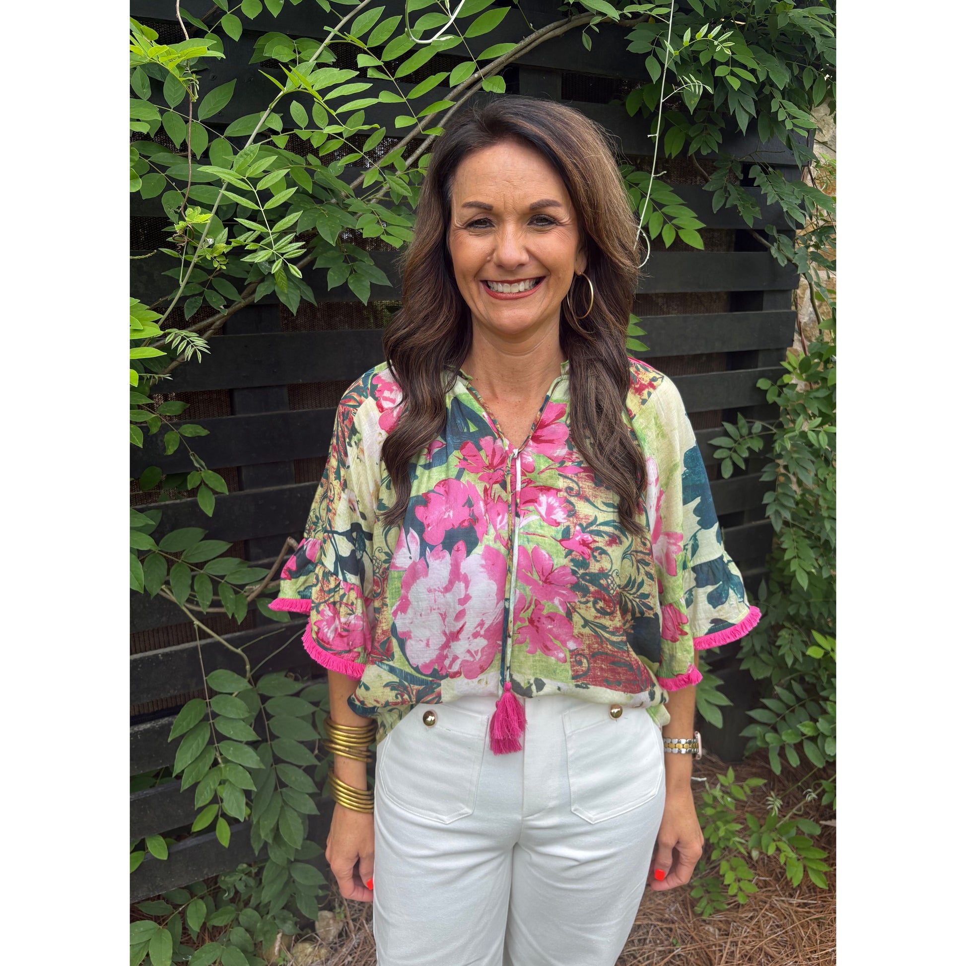 Woman wearing a floral jacket standing among green plants