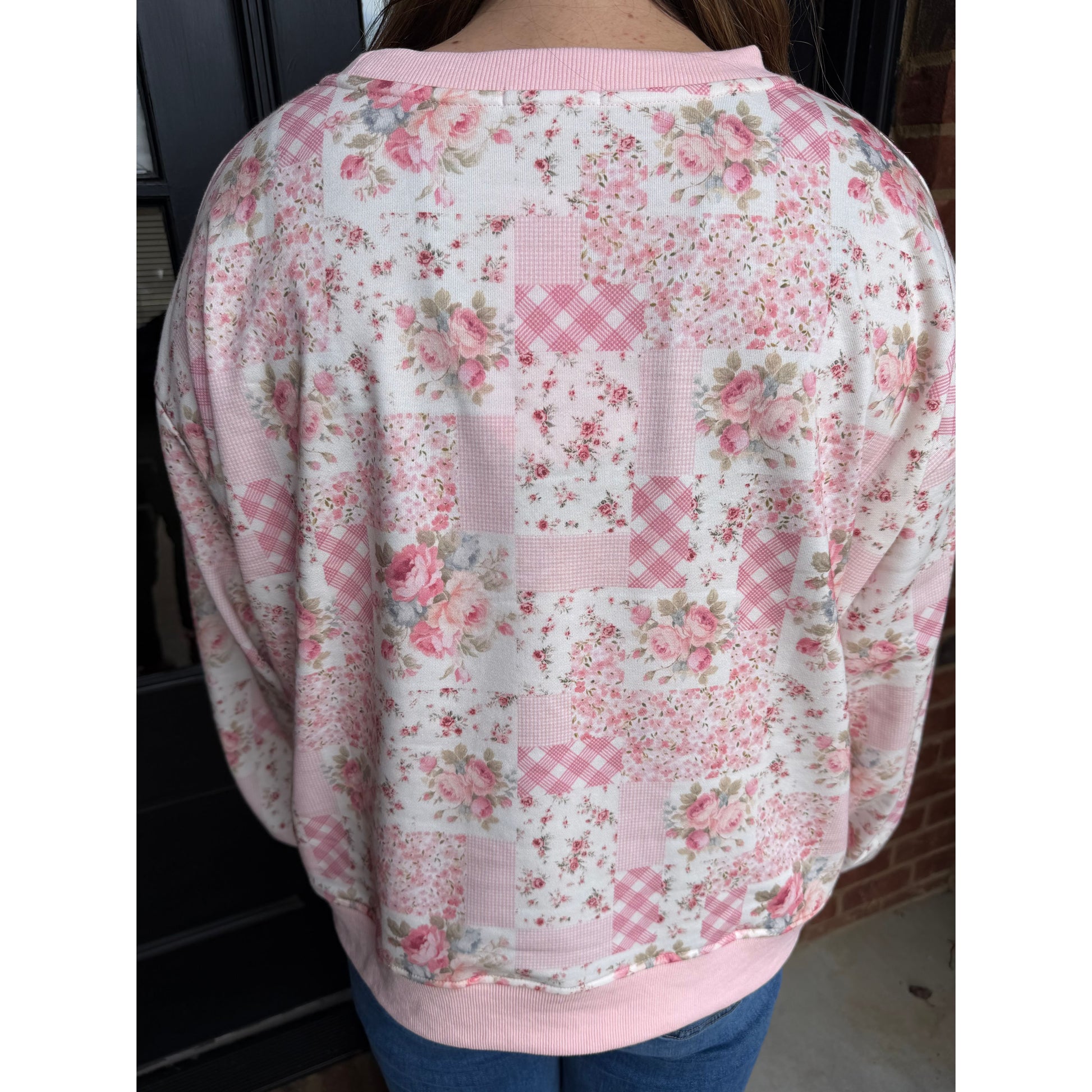 Floral-patterned fabric with pink and white design on a person's arm.