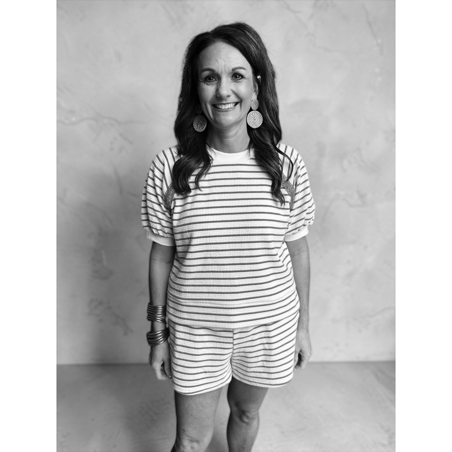 Woman wearing a striped outfit against a plain background