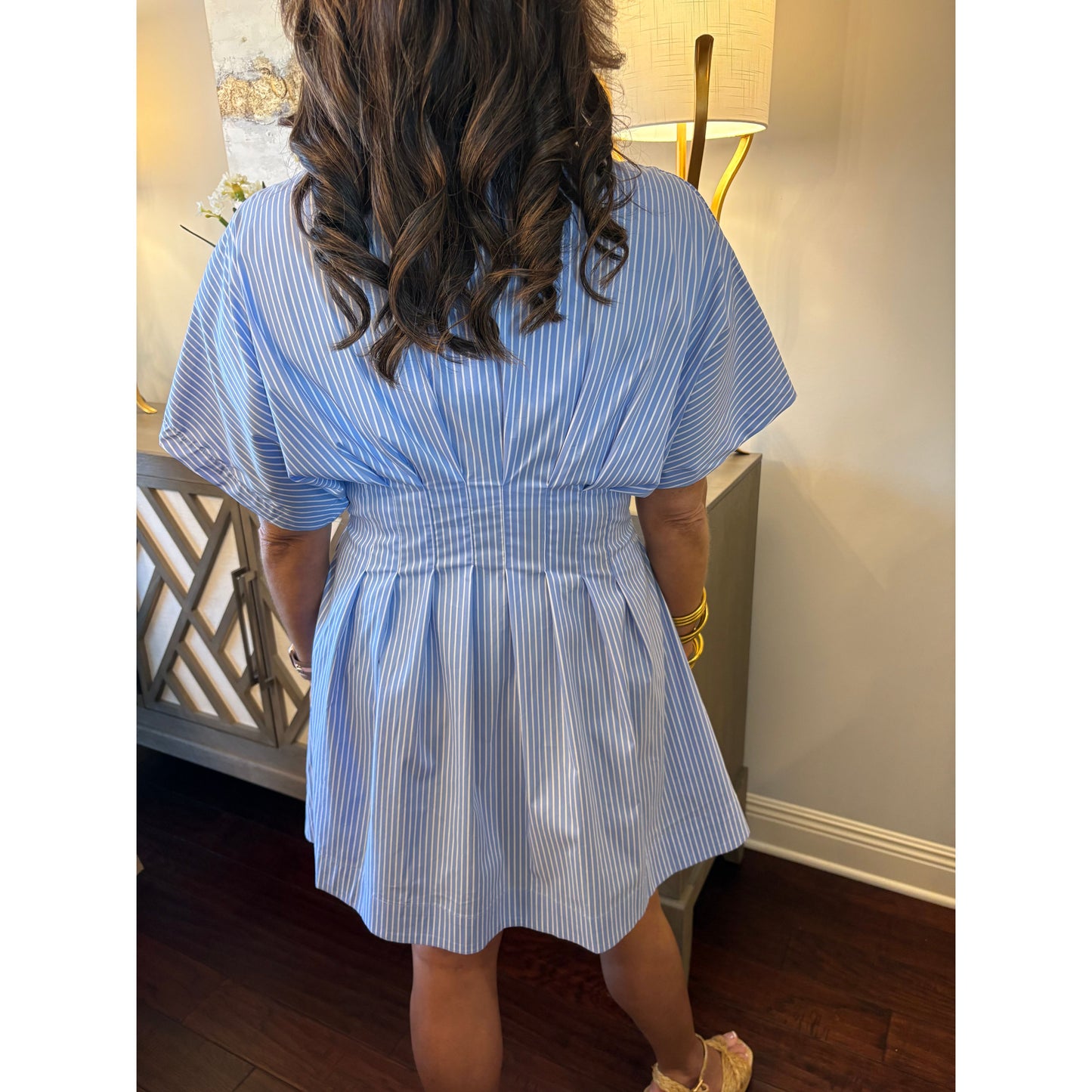 Person wearing a blue and white striped dress with a blurred background