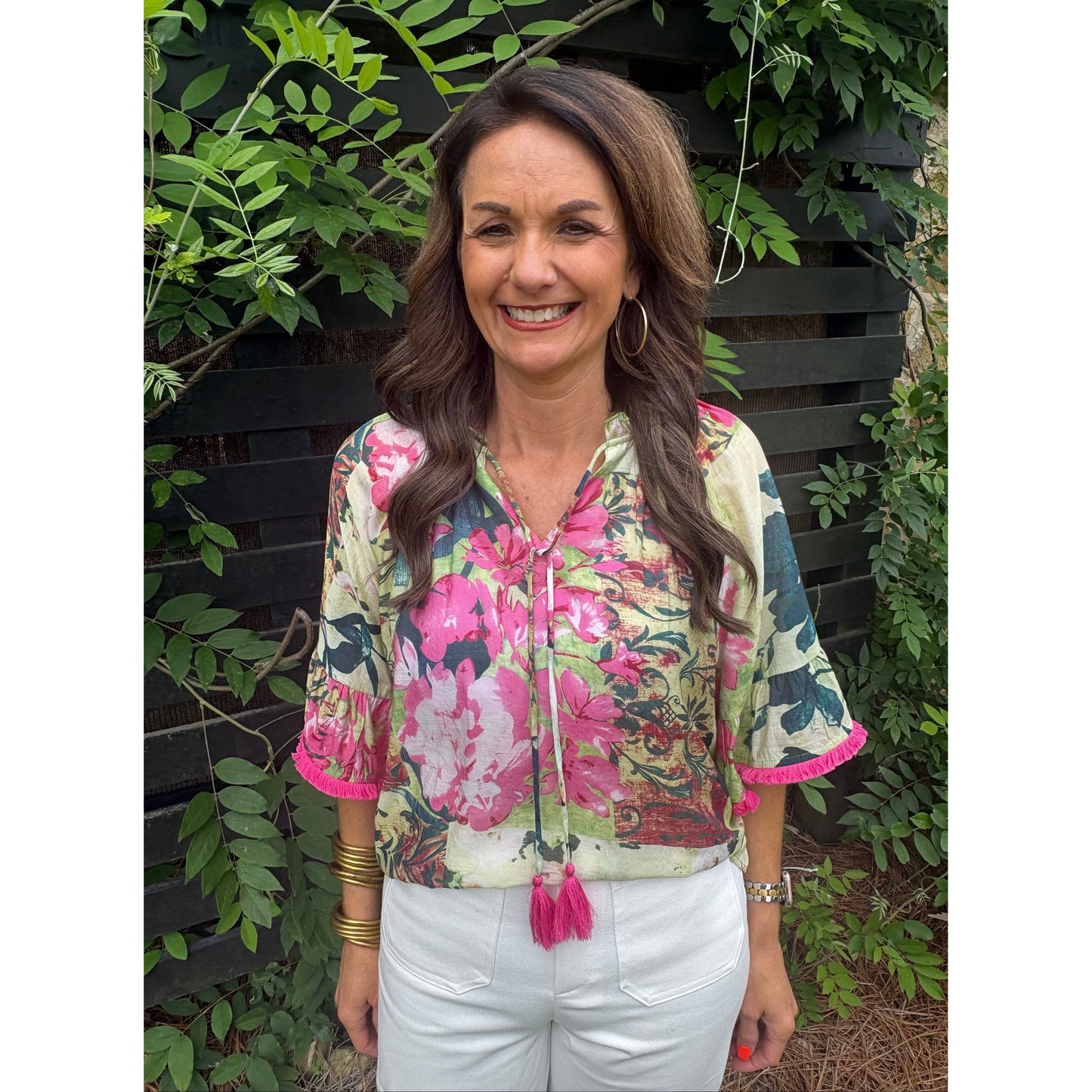Woman wearing a floral jacket among green foliage