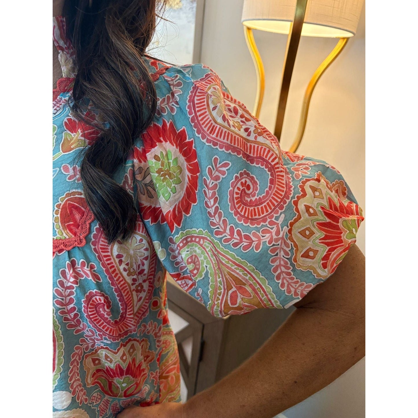 Person wearing a colorful patterned shirt with a blurred background