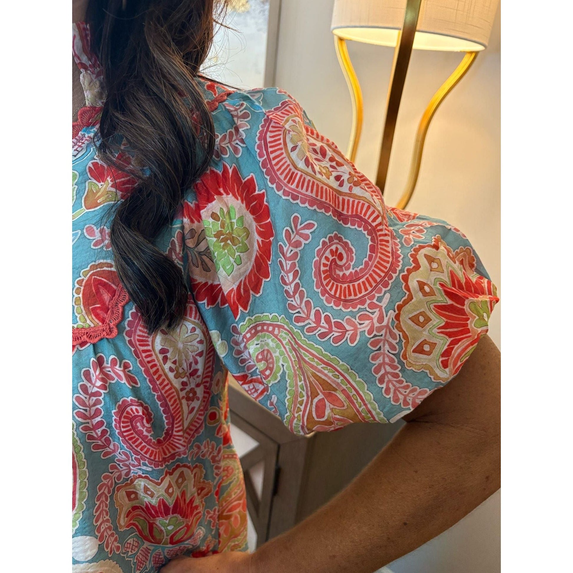 Person wearing a colorful patterned shirt with a blurred background