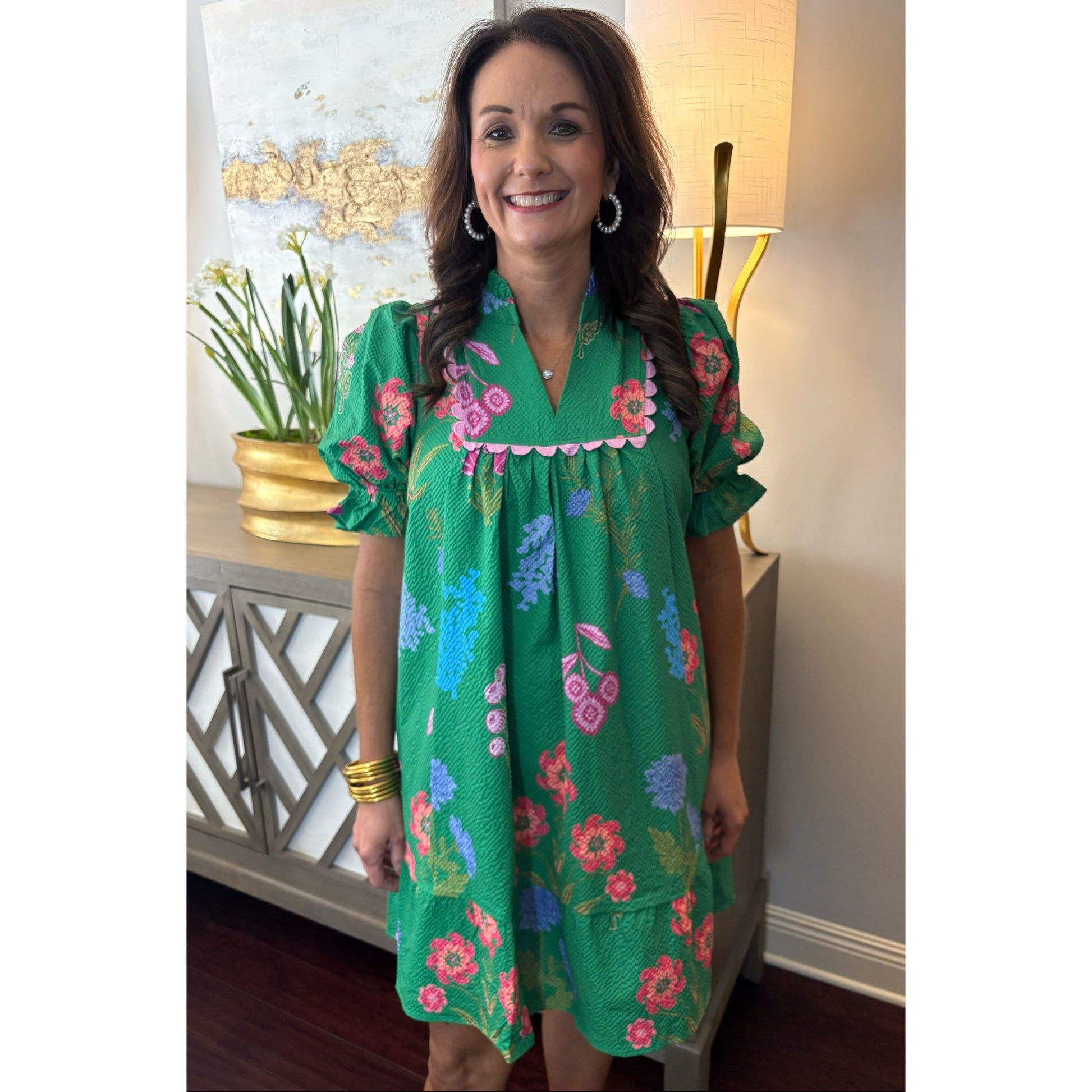 Woman wearing a green floral dress in an indoor setting