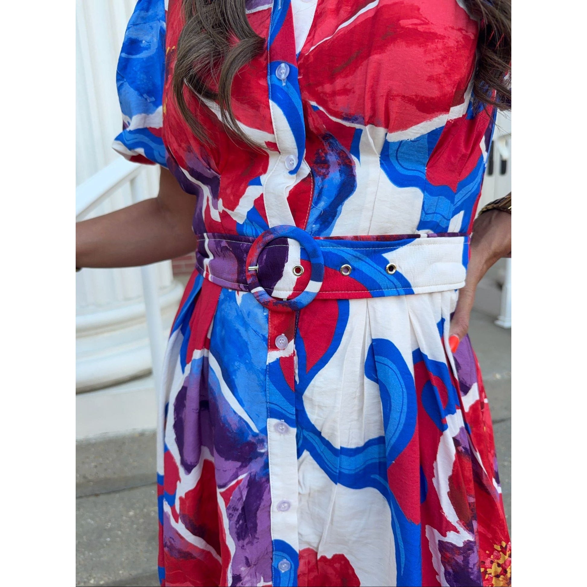 Colorful dress with red, blue, and white pattern worn by a person.