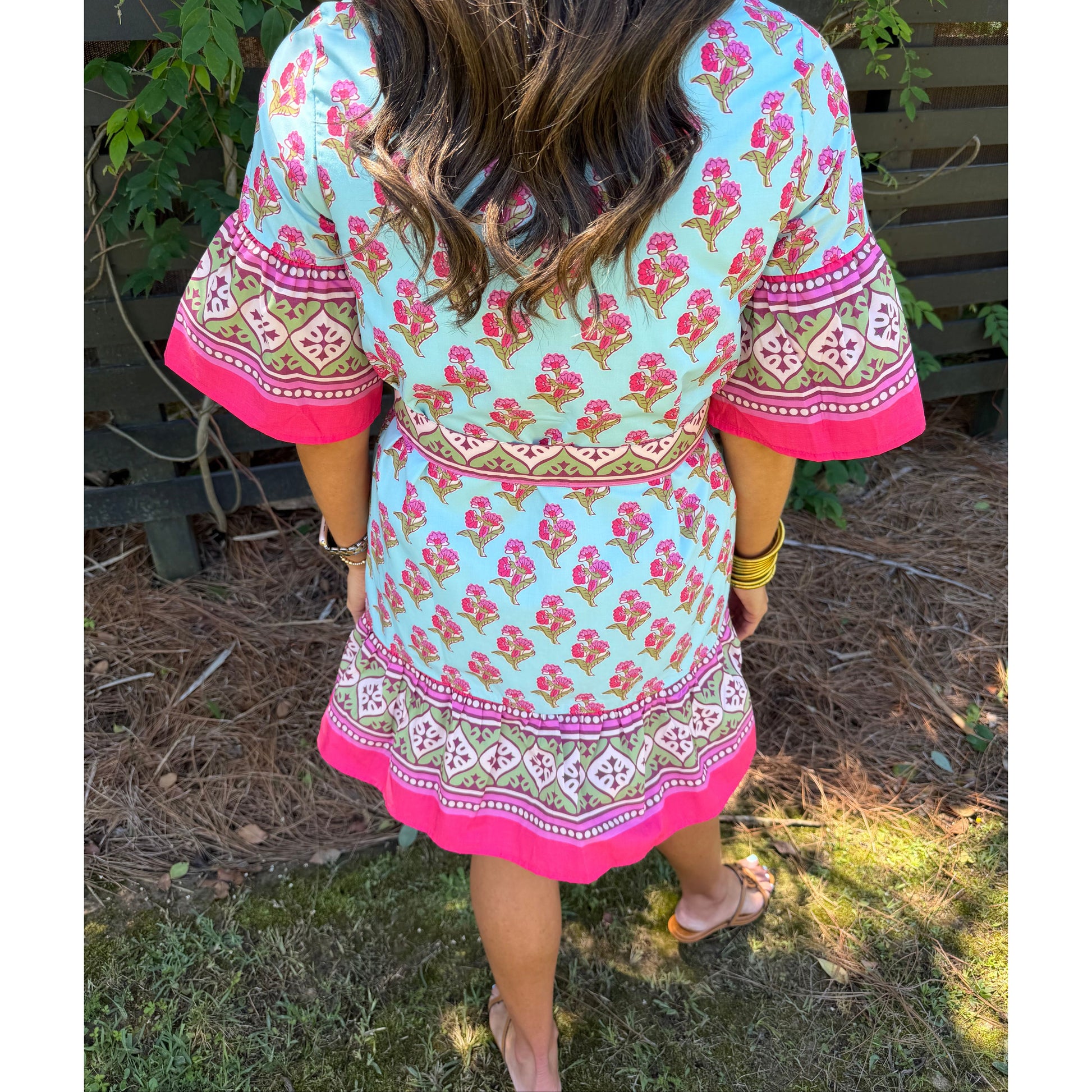 Person wearing a colorful dress with floral patterns in an outdoor setting
