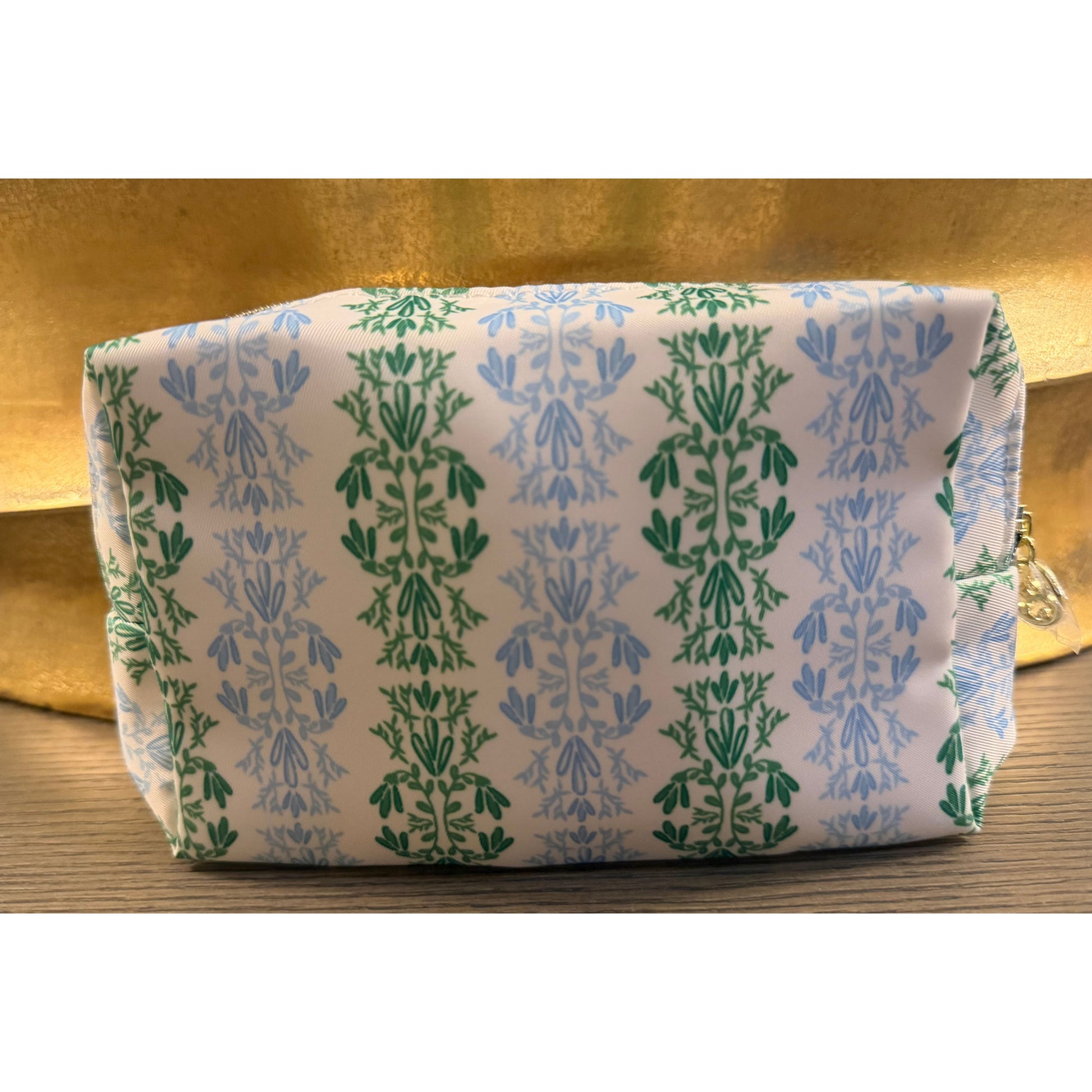 Small  cosmetic bag sitting on wood surface.