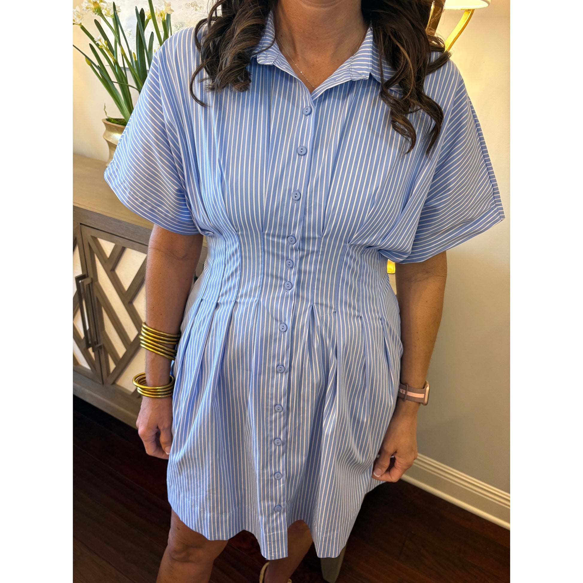 Person wearing a blue and white striped dress with a blurred background