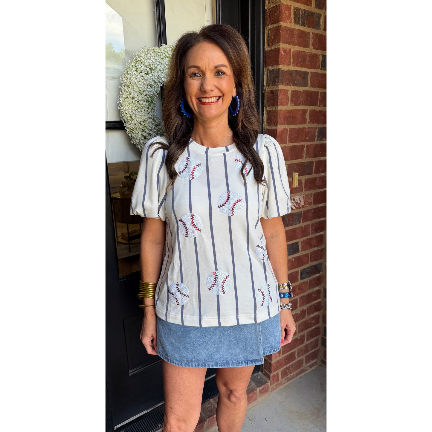 Woman standing in front of a door with a brick wall background