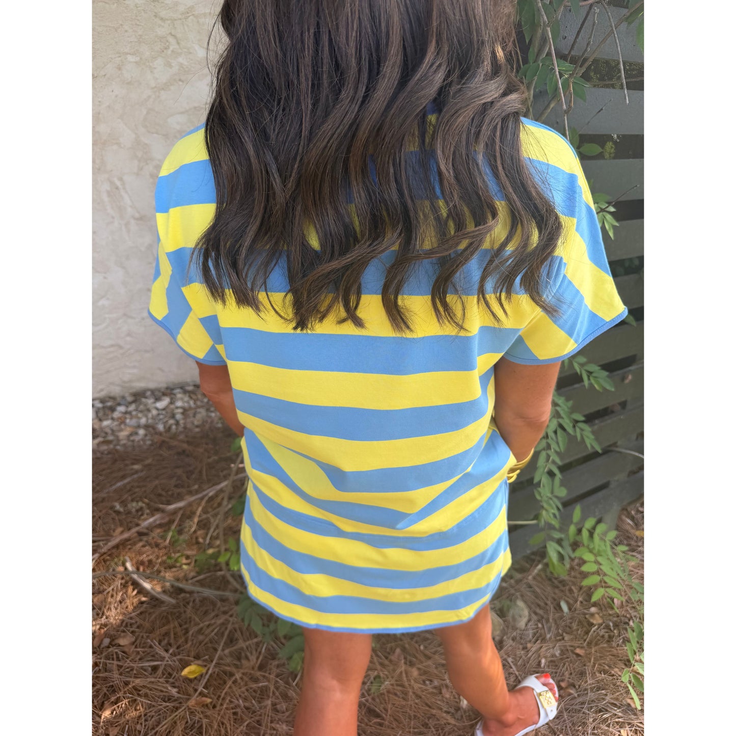 Person wearing a blue and yellow striped shirt outdoors.