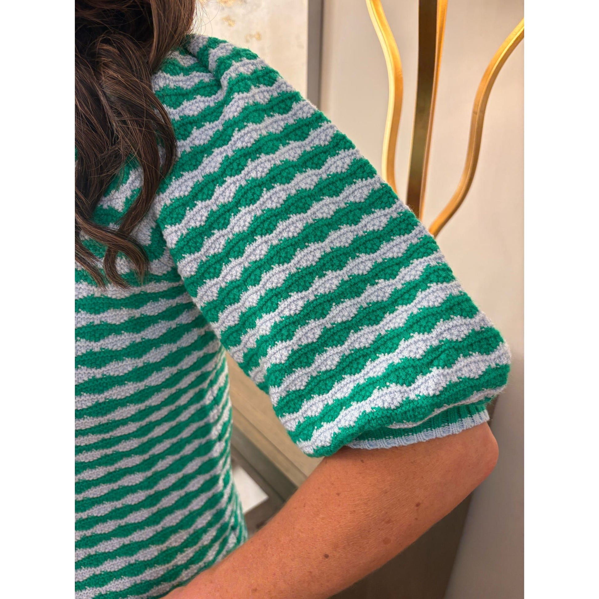 Green and white striped shirt with a blurred background