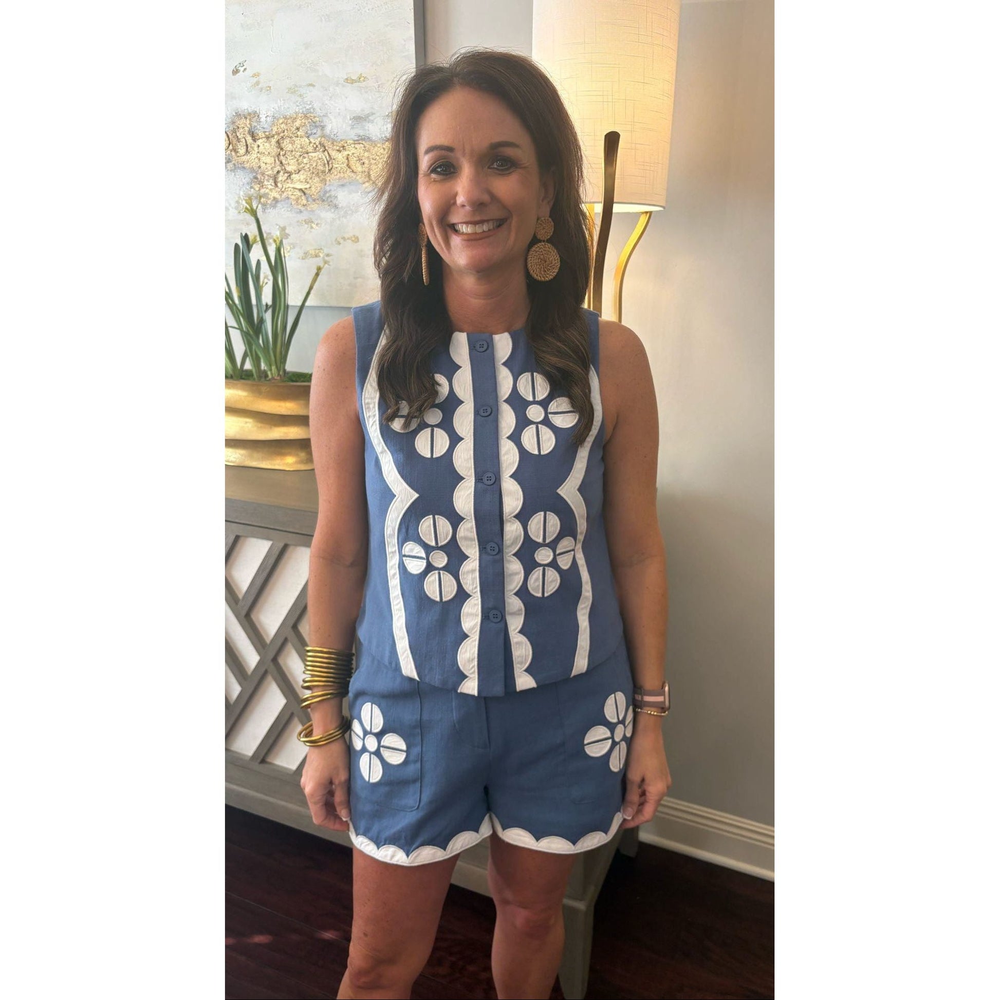 Woman wearing a blue and white patterned outfit indoors.