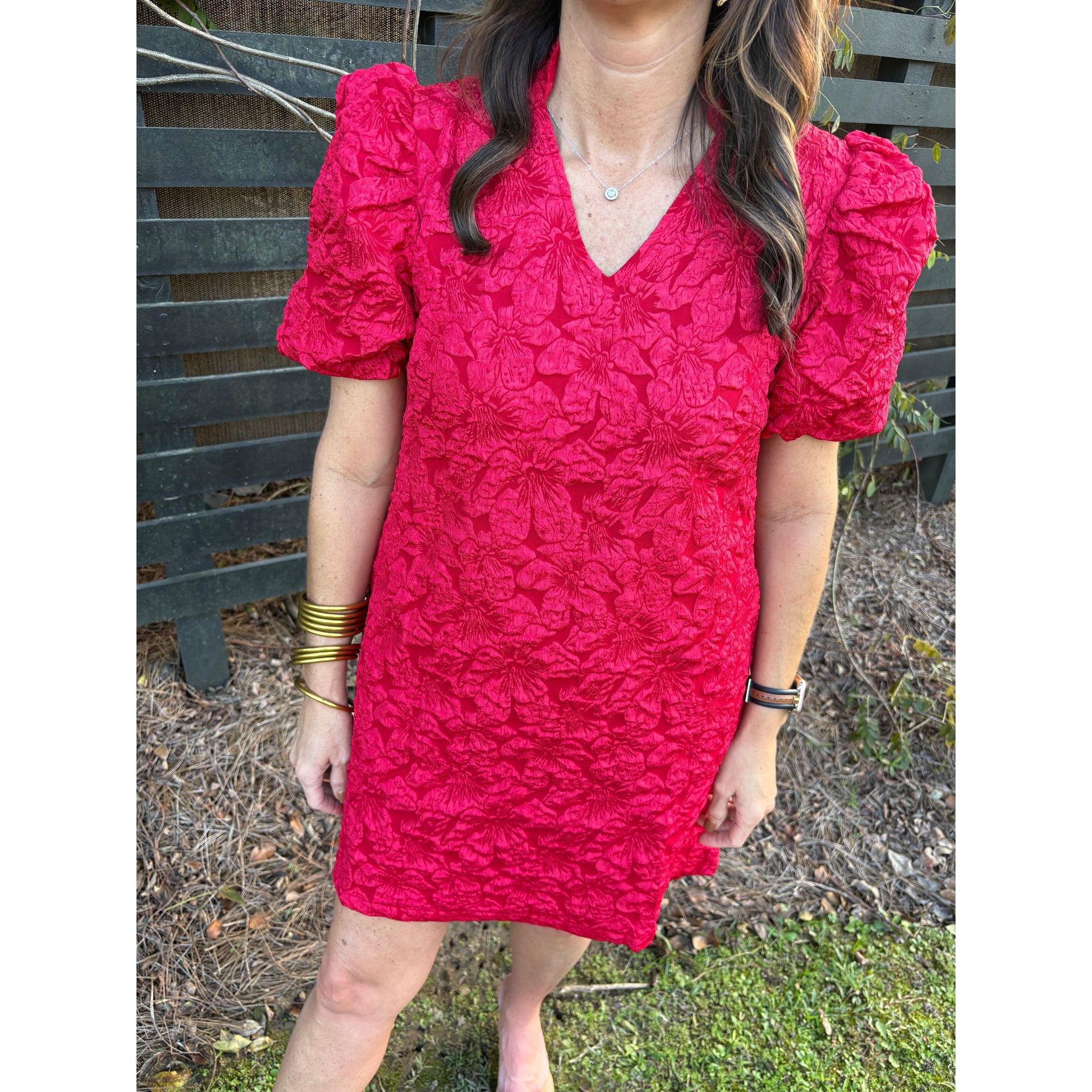 Person wearing a red textured dress with a blurred background