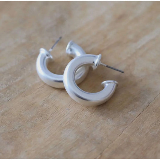 Silver hoop earrings on a wooden surface