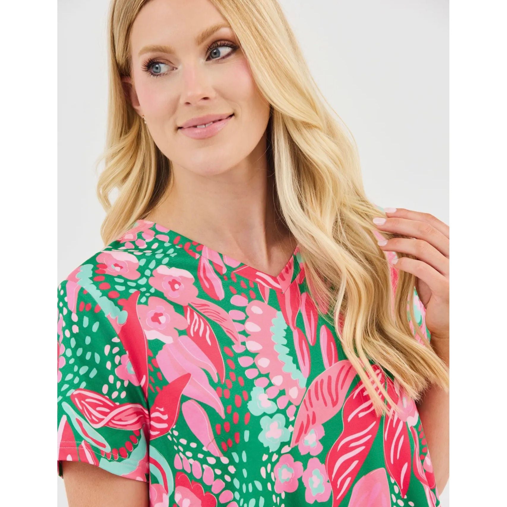 Woman wearing a colorful floral dress against a white background