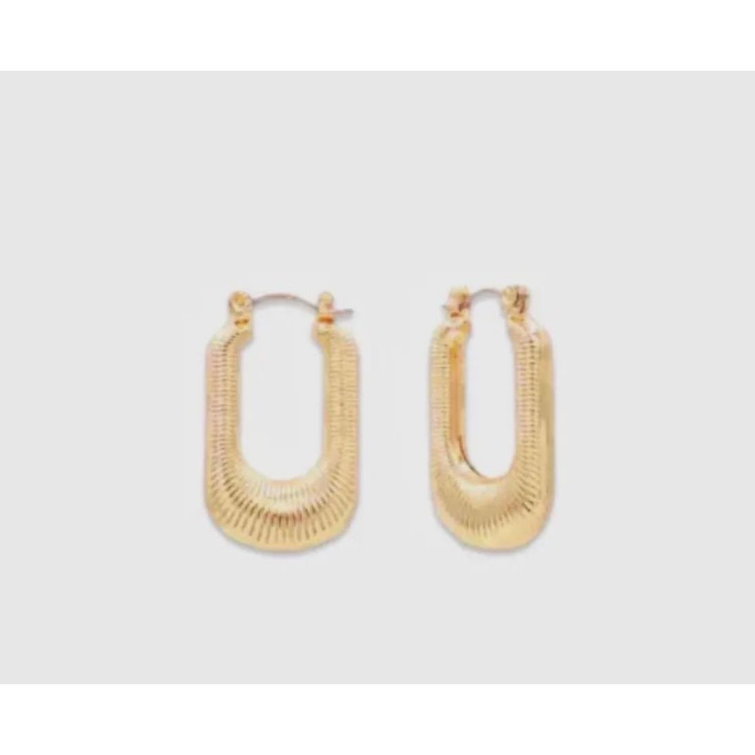 Gold hoop earrings on a light gray background
