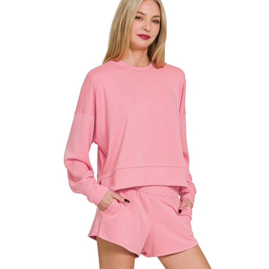 Woman wearing a pink lounge set on a white background
