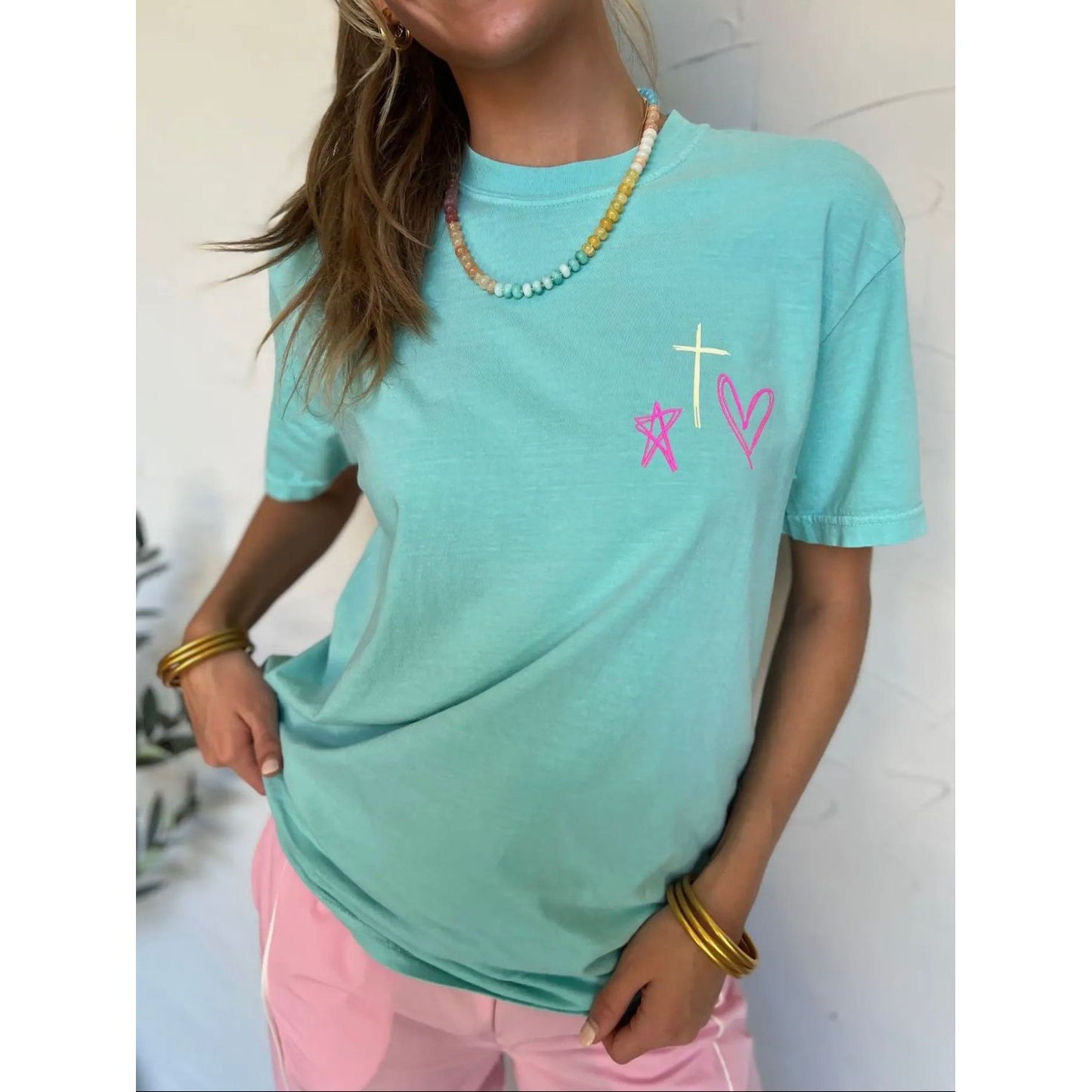 Person wearing a light blue t-shirt with colorful designs on a white background