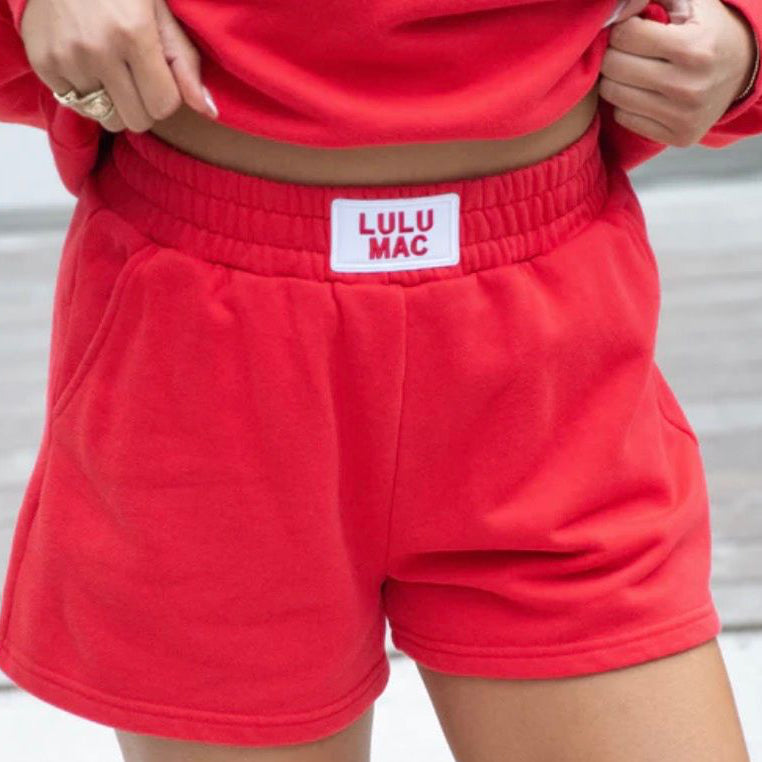 Red shorts with a visible brand label on a neutral background