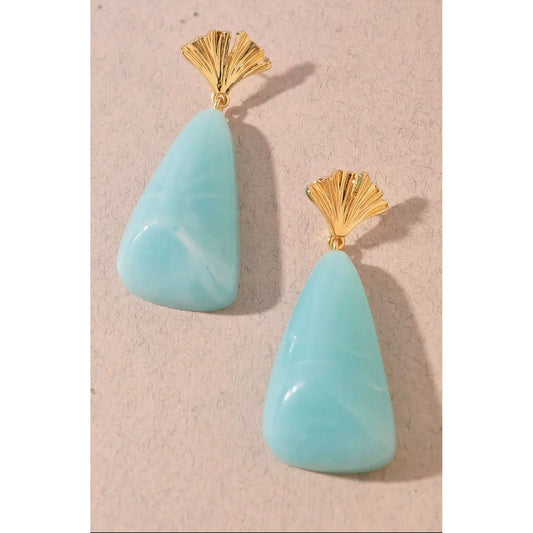 Turquoise teardrop earrings with gold fans on a beige background
