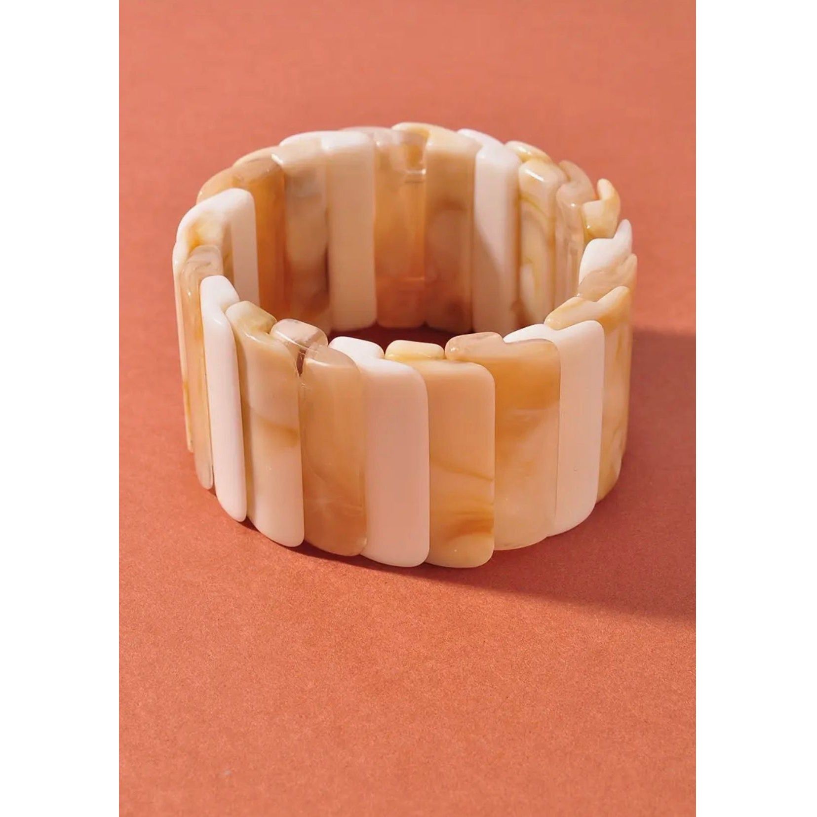 Shell bracelet on a peach-colored background