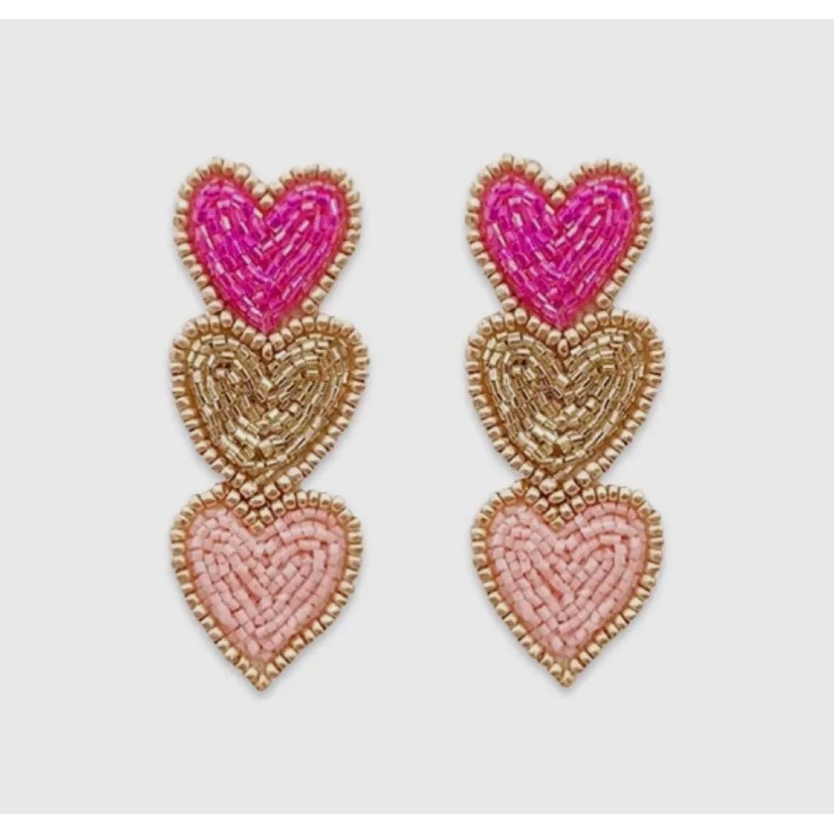 Heart-shaped earrings with pink and gold details on a light gray background