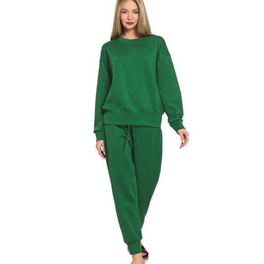 Woman wearing a green sweatshirt and pants set on a white background