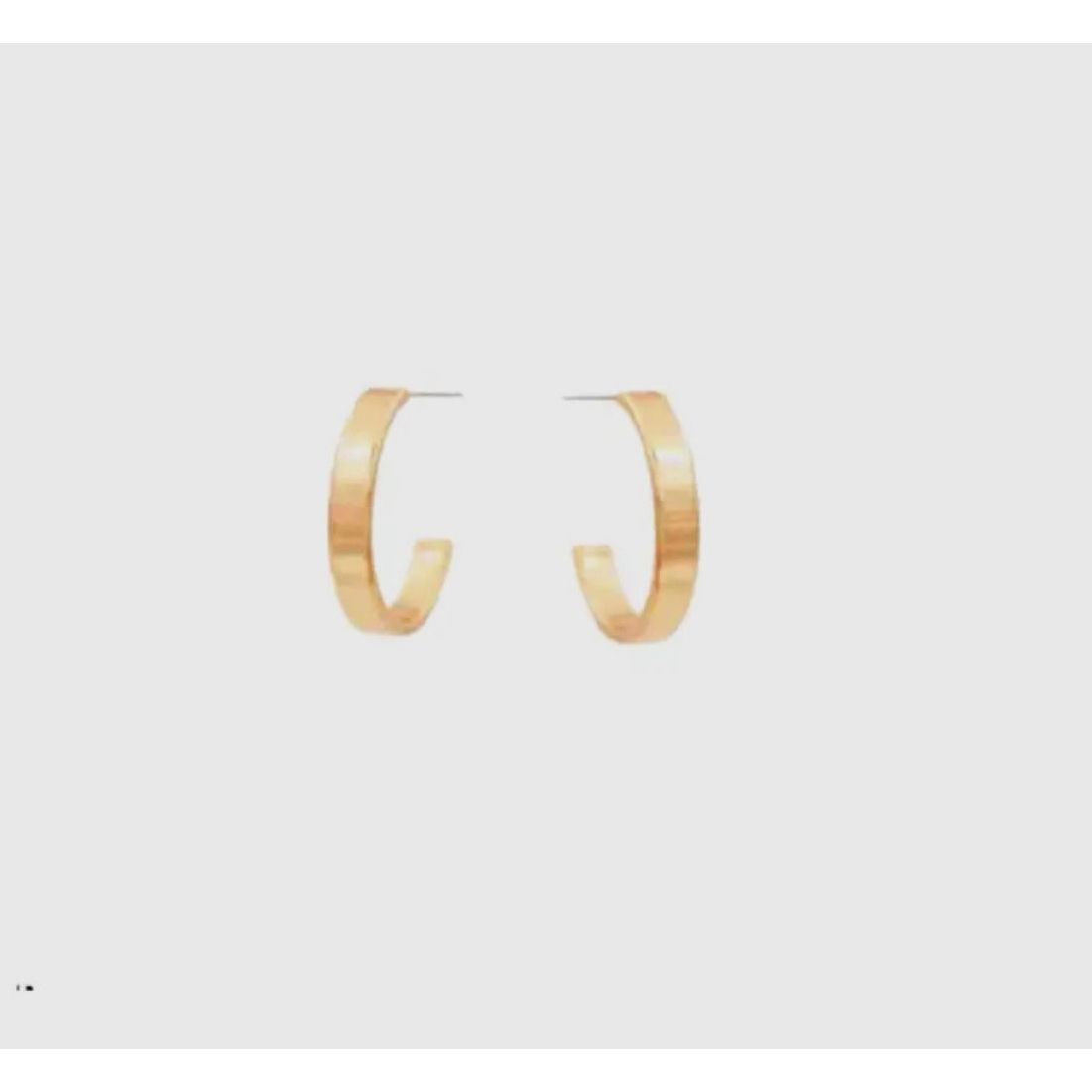 Gold hoop earrings on a light gray background