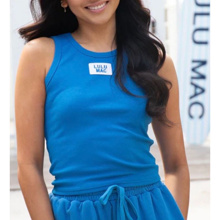 Woman wearing a blue sleeveless top with 'Lulu Mac' branding.