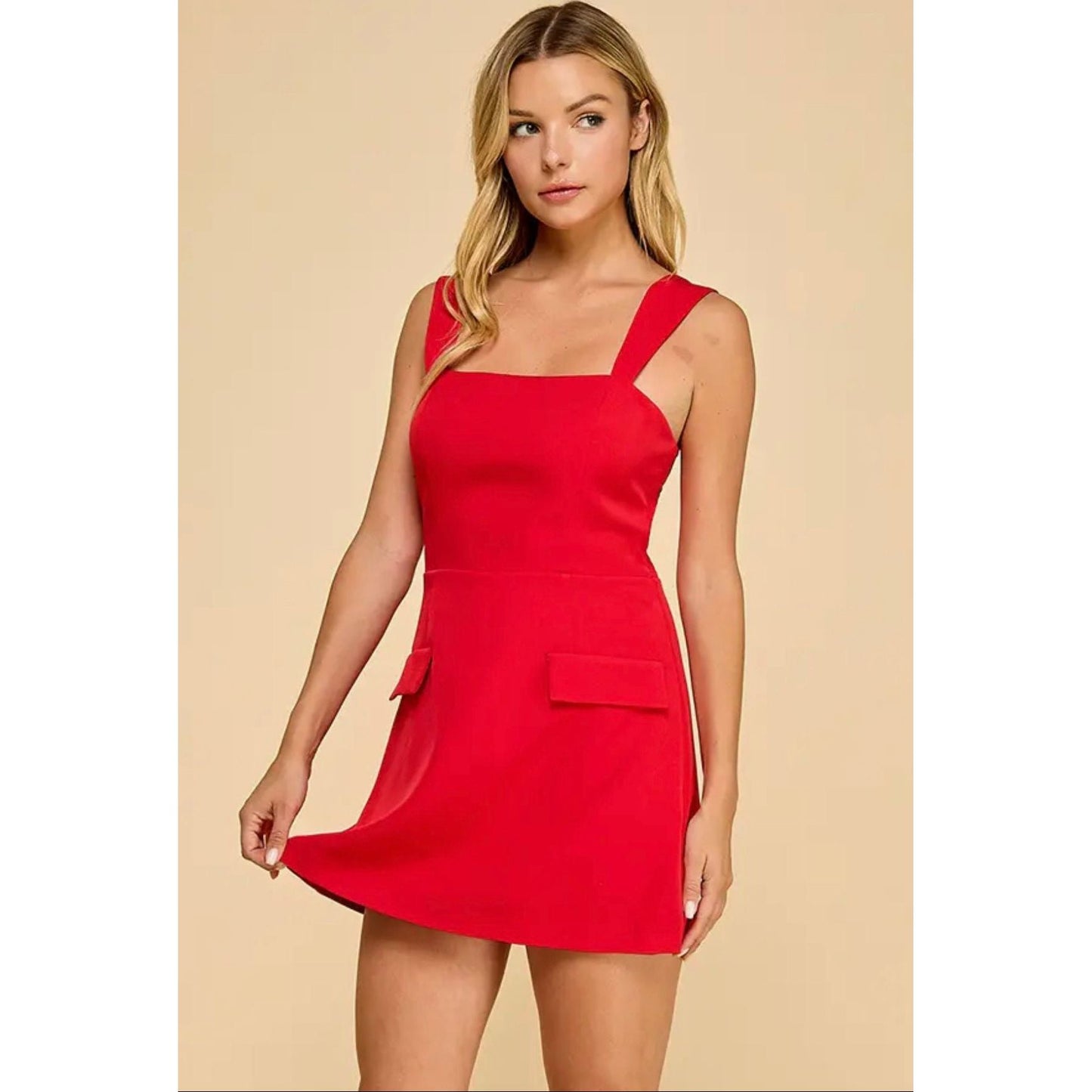 Woman wearing a red dress against a beige background