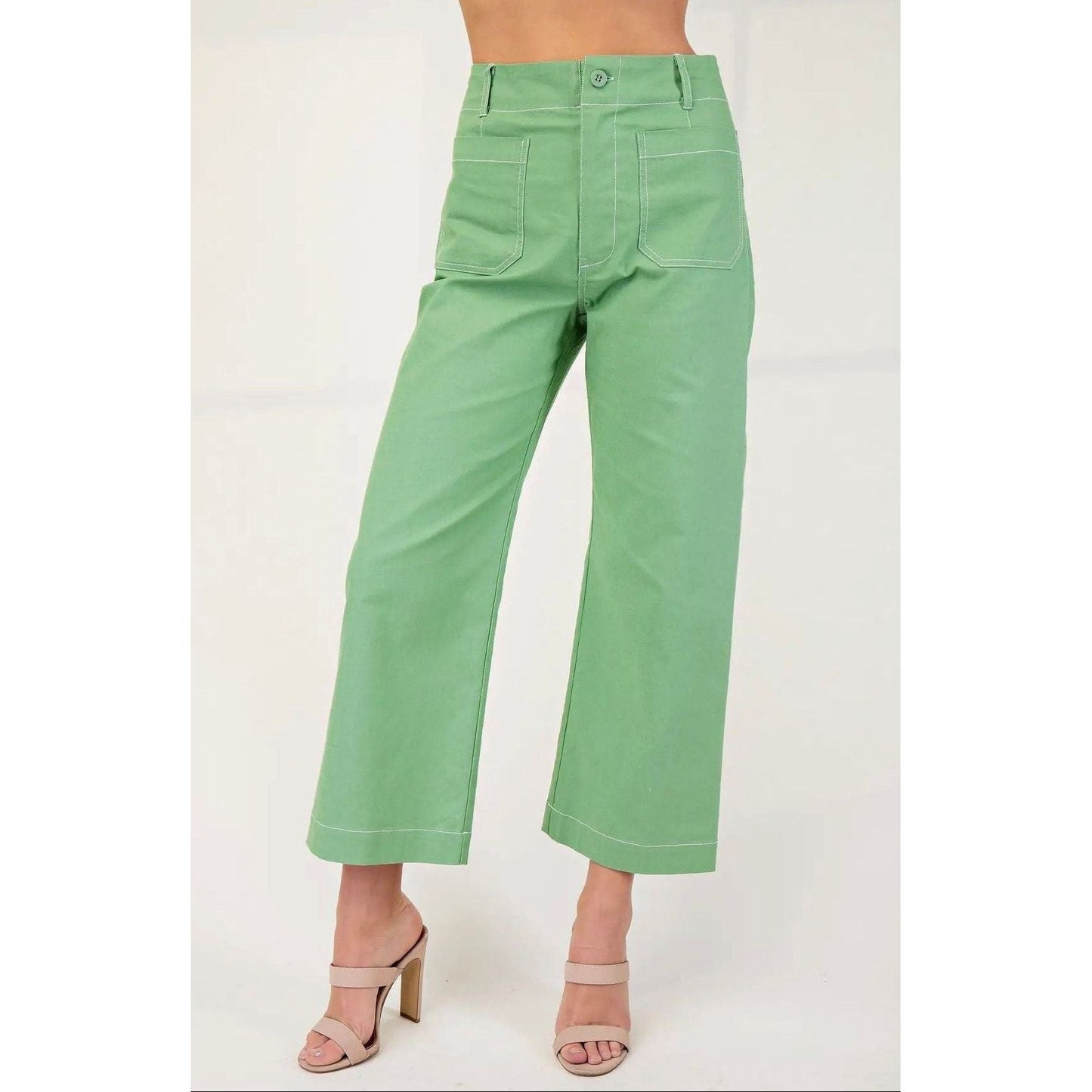 Green pants worn by a person on a white background